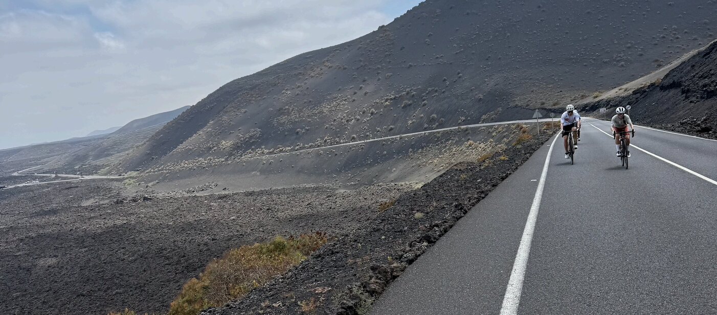 Cyclists on a volcanic road in Lanzarote during the True Program training camp